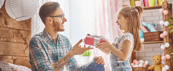 niña dándole regalo a su padre